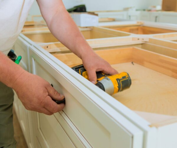 Installation of measuring drawers handles on kitchen cabinets